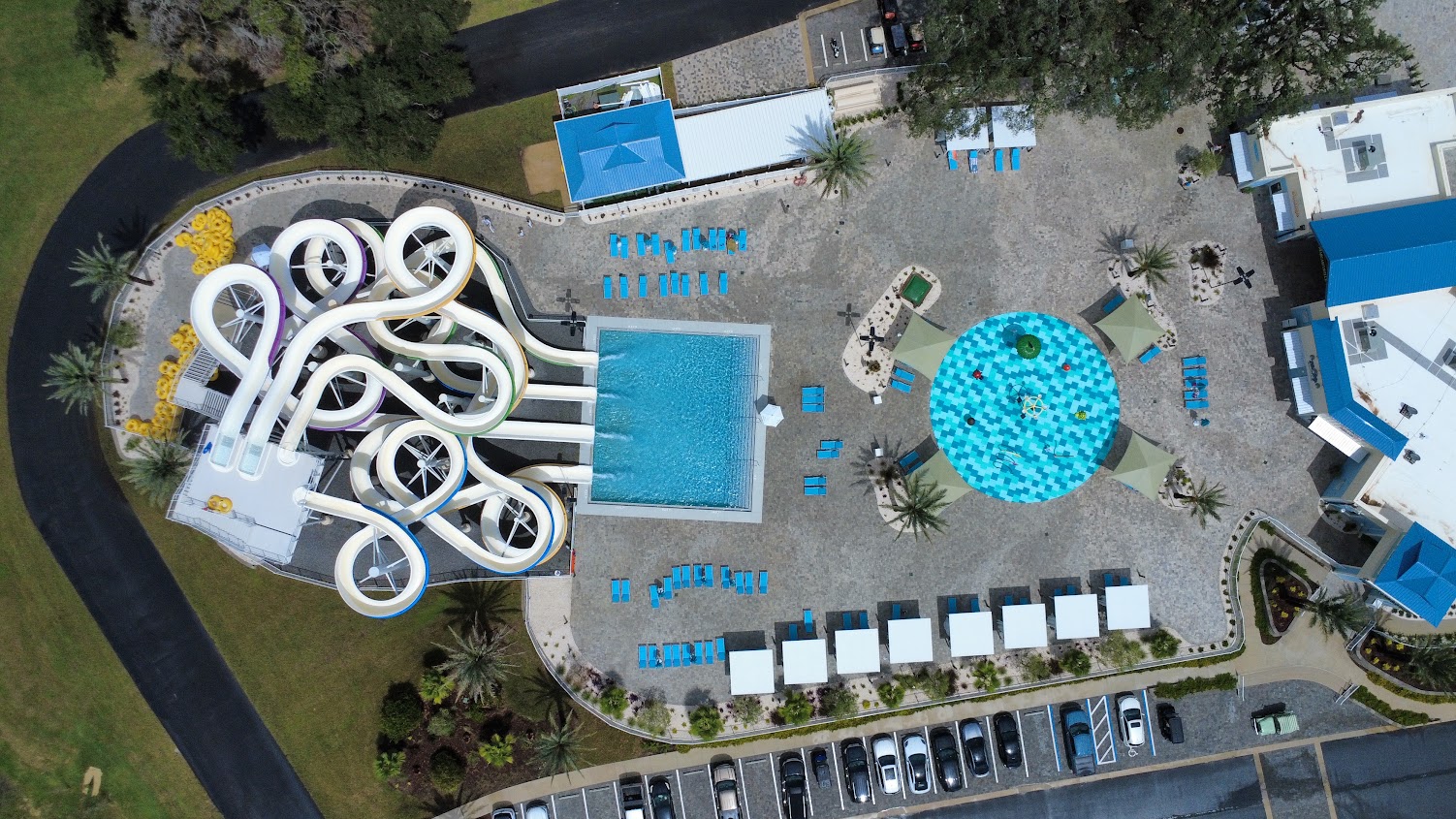 Aerial view of water slides and a pool surrounded by lounge chairs.