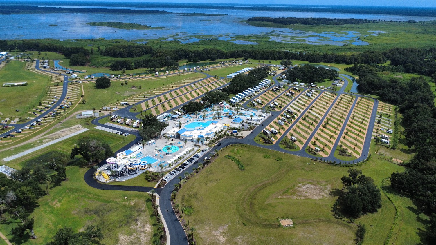 Aerial view of the campsite with RVs, pool, and natural surroundings.