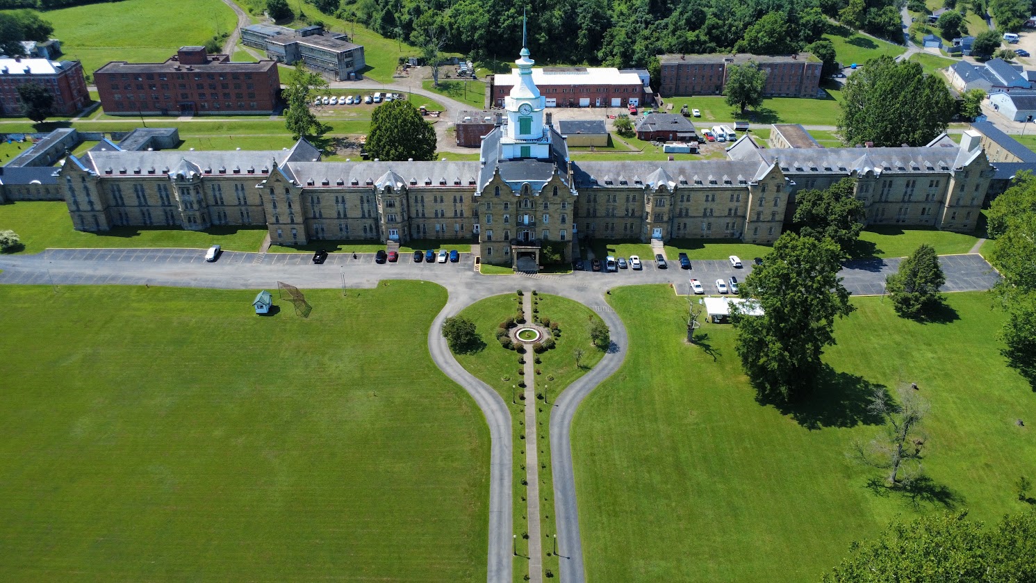 Aerial view of the Trans-Allegheny Lunatic Asylum surrounded by green lawns.